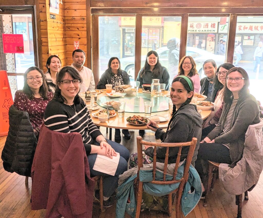 11 APALA Northeast Chapter members pose for the camera, seated at a round table at a restaurant.